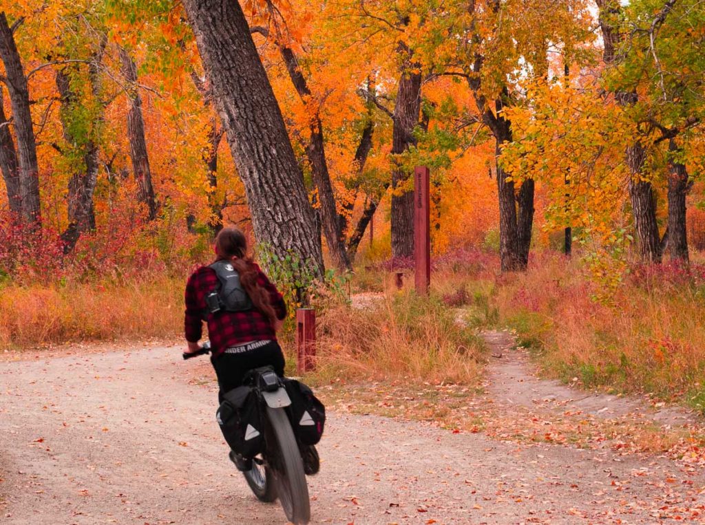 fall season photo shoot of a man biking at st. george park calgary city